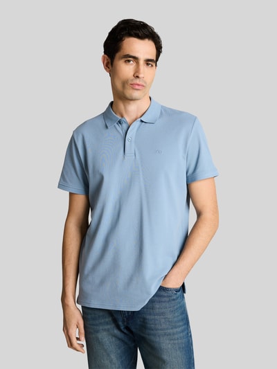 Männermodel trägt Regular Fit Poloshirt aus reiner Baumwolle von Tom Tailor, Optik: Unifarben, Logo-Stitching, Piqué, Ganzkörperansicht von vorne.