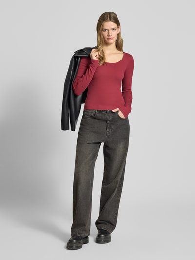 Frauenmodel trägt Slim Fit Longsleeve mit tiefen Rundhalsausschnitt von Review in Rot, Strukturmuster, elastischer Baumwoll-Mix, Ganzkörperansicht von vorne.