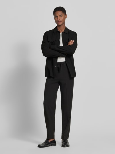 Männermodel trägt Relaxed Fit Hemdjacke mit Brusttaschen von Lindbergh, Material-Mix mit Viskose-Anteil, Schwarz, Ganzkörperansicht von vorne.