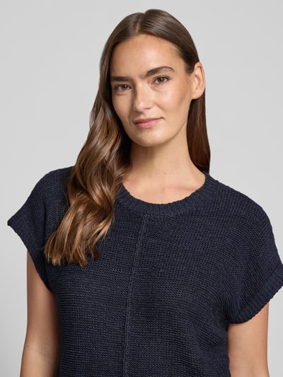 Frauenmodel trägt Strickshirt mit Kappärmeln Modell 'Estapper' von FREE/QUENT in Dunkelblau, Regular-Fit, Rundhalsausschnitt, Nahaufnahme Oberkörper. Rückenlänge bei Größe S: 55 cm, Ärmellänge bei Größe S: 24 cm. Textur: grob gestrickt.