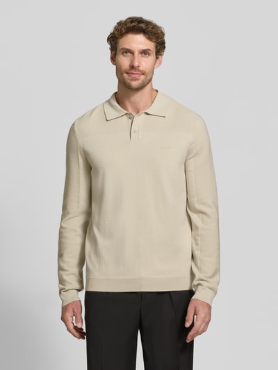 Männermodel trägt cremefarbenes Relaxed Fit Poloshirt mit Woll-Anteil Modell 'KN_Momentum-X PL' von BOSS Green, Ganzkörperansicht von vorne.