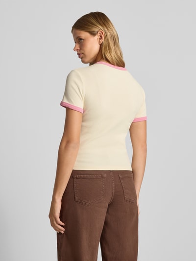 Frauenmodel trägt T-Shirt mit Motiv-Print Modell 'Lucky' von OH APRIL, cremefarben mit rosa Kontraststreifen, Feinripp, Ganzkörperansicht Rückansicht.