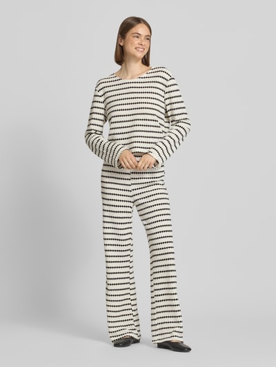 Frauenmodel trägt Loose Fit Stoffhose mit Baumwoll-Anteil Modell 'EVA LIFE' von Only in Optik: Allover-Muster mit Struktur, Flared, Material-Mix aus Strick, Ganzkörperansicht von vorne.