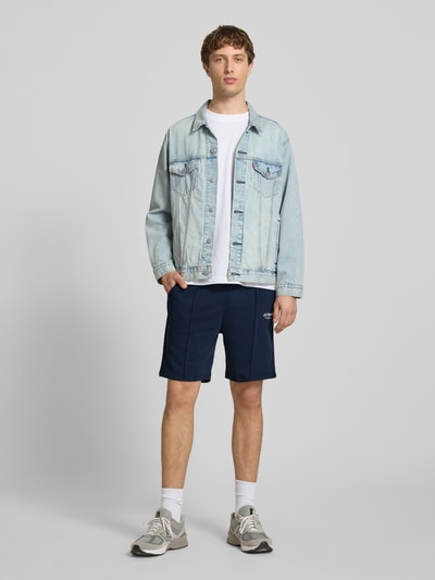 Männermodel trägt Sweatshorts mit Logo Modell 'KANE' von Jack & Jones, dunkelblau, Baumwoll-Mix, Relaxed-Fit, elastischer Bund, Ganzkörperansicht von vorne.