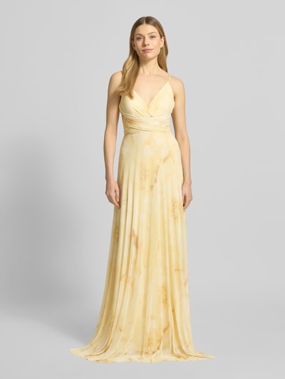 Frauenmodel trägt Regular Fit Abendkleid mit V-Ausschnitt von Jake*s Cocktail in hellem Gelb mit Spaghettiträgern, Ganzkörperansicht von vorne. Elastischer Material-Mix, taillierte Passform, Raffungen, Rückenausschnitt mit Schnürverschluss, fließende Textur.