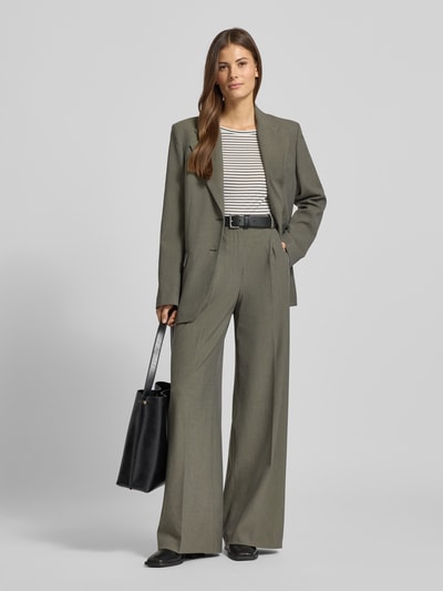 Frauenmodel trägt Wide Fit Bundfaltenhose mit Viskose-Anteil Modell 'Napoli' von Mango in Grau, Bügelfalten, Ganzkörperansicht von vorne.