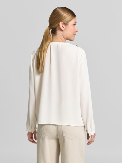 Frauenmodel trägt Regular Fit Bluse mit Volants von Marc Cain in Creme mit V-Ausschnitt und Label-Detail, Ganzkörperansicht Rückansicht.