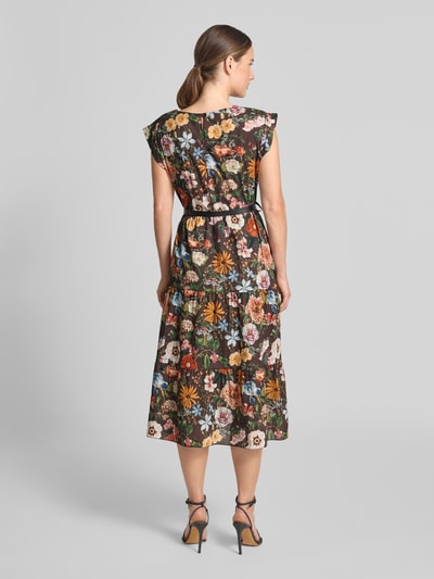 Frauenmodel trägt Midikleid mit Gürtel von ZABAIONE, florales Muster, reine Baumwolle, taillierte Passform, Stufen-Look, Ganzkörperansicht Rückansicht.