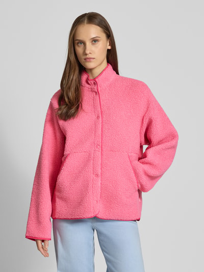 Frauenmodel trägt Relaxed Fit Fleecejacke mit Stehkragen Modell 'VERA' von JJXX aus pinkem Teddyfell mit Knopfleiste und Eingrifftaschen, Rückenlänge 57 cm, Schulterbreite 41 cm, Brustweite 53 cm, Ärmellänge 54 cm, Ganzkörperansicht von vorne.