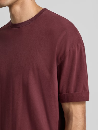 Männermodel trägt Regular Fit T-Shirt aus reiner Baumwolle Modell 'Thilo' von DRYKORN in Dunkelrot, Nahaufnahme Oberkörper, Rundhalsausschnitt, Rückenlänge 71 cm bei Größe M.