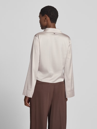 Frauenmodel trägt Relaxed Fit Langarmbluse in Satin-Optik Modell 'ERRIKA' von HUGO in hellem Beige, glatte Oberfläche, Damen Langarmbluse, Ganzkörperansicht Rückansicht.