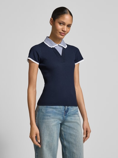 Modelka nosi Strickshirt mit Hemdblusenkragen od Rich & Royal, bawełna z elastanem, krój slim fit, granatowy, tekstura prążkowana, widok całej sylwetki z przodu.
