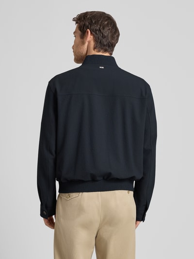 Männermodel trägt Regular Fit Blouson mit Baseball-Kragen Modell 'H-COMBO' von BOSS, dunkelblau, Seersucker, Optik:Allover-Muster, Ganzkörperansicht Rückansicht.