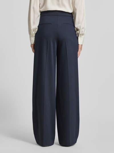 Frauenmodel trägt Wide Fit Stoffhose mit Viskose-Anteil von Christian Berg Woman Selection in Dunkelblau, Ziersteinbesatz, Ganzkörperansicht Rückansicht, Elastischer-Material-Mix, Haken-Reißverschluss, Bundweite 40 cm, Innenbeinlänge 83 cm bei Größe 36.