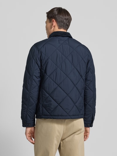Männermodel trägt Regular Fit Steppjacke mit Kentkragen von Polo Ralph Lauren, dunkelblau, Rückenlänge 70 cm, Ganzkörperansicht Rückansicht.