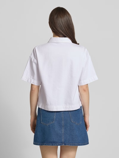 Frauenmodel trägt Loose Fit Jeansbluse aus reiner Baumwolle Modell 'SKY' von Pieces, weißer Denim, kurzarm, Ganzkörperansicht Rückansicht.