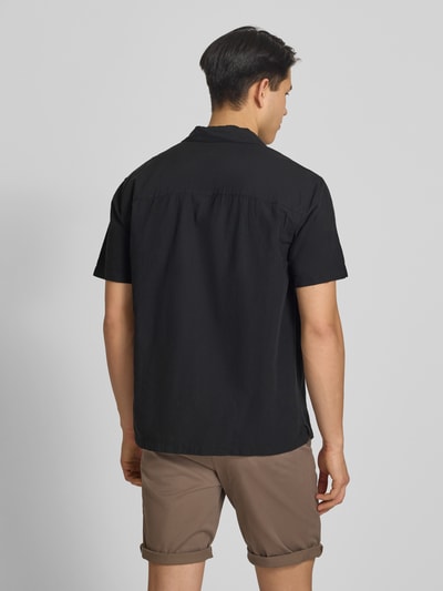 Mannelijk model draagt Regular Fit vrijetijdsoverhemd uit mix van katoen en linnen van Jack & Jones, model 'BREEZE', reverskraag, knoopsluiting, ruglengte bij maat M 71 cm, schouderbreedte 50 cm, mouwlengte 26 cm, effen zwart, zachte textuur, casual uitstraling, geheelopname achteraanzicht.