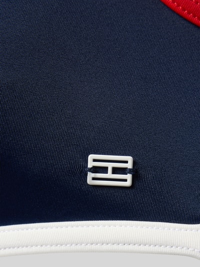 Produktfoto, Bikini-Oberteil mit Logo-Applikation von Tommy Hilfiger, efekt: wielokolorowy, aplikacja: paski w kontrastowym kolorze, dekolt w serek, bez fiszbin, detal miseczki: niewyściełane, szerokie ramiączka, bez zapięcia, tekstura gładka, detale: logo