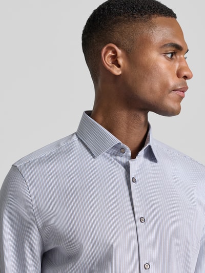 Männermodel trägt Slim Fit Business-Hemd mit Kentkragen von OLYMP Level Five, Baumwoll-Mix mit Stretch-Anteil, Nahaufnahme Oberkörper.