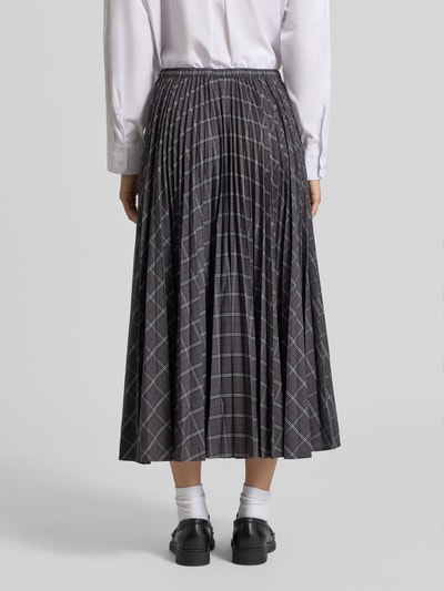 Frauenmodel trägt Midirock mit elastischem Bund Modell 'AURORA' von Cph Muse, Material-Mix, Falten, dunkler Allover-Look, Ganzkörperansicht Rückansicht.