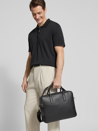 Männermodel trägt Laptop Tasche in Leder-Optik Modell 'Commuter' von CK Calvin Klein, schwarze Farbe, Strukturmuster, Nahaufnahme Oberkörper