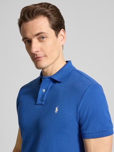 Männermodel trägt Regular Fit Poloshirt aus reiner Baumwolle von Polo Ralph Lauren in Uni-Blau mit Logo-Detail, Nahaufnahme Oberkörper.