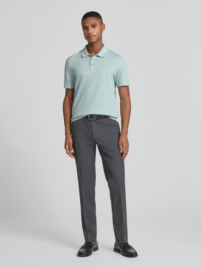 Männermodel trägt Poloshirt mit kurzer Knopfleiste Modell 'Roni' von JOOP! Collection, hellgrün, klassische Passform, Ganzkörperansicht von vorne.