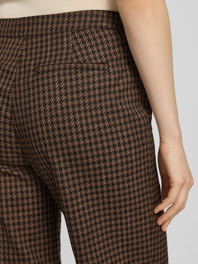 Frauenmodel trägt Wide Leg Pants mit aufgesetzten Eingrifftaschen von Christian Berg Woman, braun gemustert, Material-Mix mit Viskose-Anteil, Nahaufnahme Oberschenkel rückseitig.