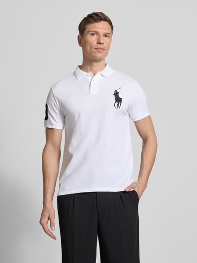 Männermodel trägt Shaped Fit Poloshirt aus reiner Baumwolle von Polo Ralph Lauren, Optik: Unifarben, Logo-Stitching, Polokragen, Ganzkörperansicht von vorne.