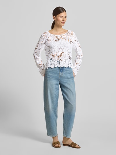 Frauenmodel trägt Strickshirt mit Häkelspitze Modell 'Cornelly' von monari, weiß, lockerer Schnitt, Rundhalsausschnitt, Ganzkörperansicht von vorne.