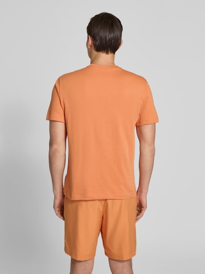 Männermodel trägt Regular Fit T-Shirt aus Baumwoll-Mix von Lacoste Sport in Orange, unifarben, kurzarm, Rückansicht Ganzkörperansicht.