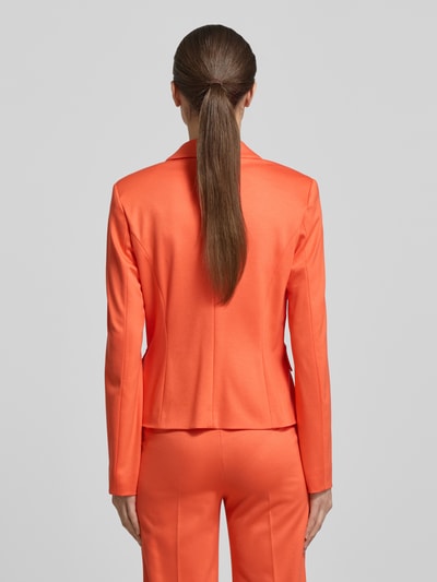 Frauenmodel trägt Slim Fit Blazer aus Viskose-Mix von Marc Cain in Orange mit Reverskragen, Pattentaschen, 2-Knopfleiste, Rückenansicht. Rückenlänge 55 cm, Brustweite 41 cm, Ärmellänge 62 cm, Größe 36.