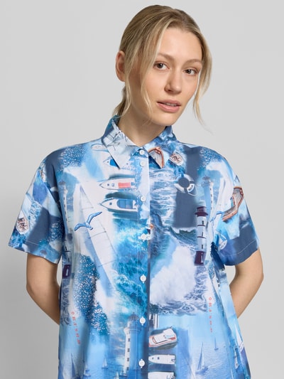Vrouwenmodel draagt Relaxed Fit Hemdblusenkleid met all-over fotoprint van Marc Cain, puur katoen, platte kraag, knoopsluiting, met korte mouwen, borstwijdte maat 36: 56 cm, maat 36, detailopname bovenlichaam.