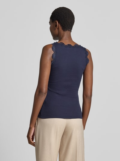 Vrouwenmodel draagt Slim Fit Top met Spitzenbesatz uit puur katoen van Rich & Royal in donkerblauw met ronde hals, ruglengte bij maat S 56 cm, ganzebody-aanzicht achteraan.