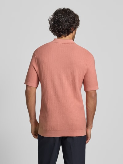 Männermodel trägt Regular Fit Poloshirt aus reiner Bio-Baumwolle Modell 'CRAN' von SELECTED HOMME in Strickoptik, Ganzkörperansicht Rückansicht.