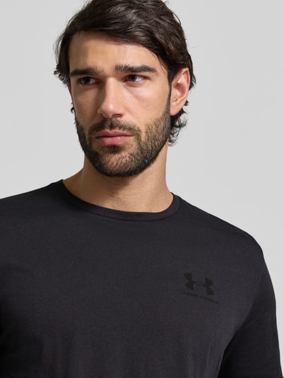 Męski t-shirt od Under Armour Regular Fit T-Shirt mit Logo-Print Modell 'Left' z mieszanki bawełny, okrągły dekolt, nadruk z logo, kolor czarny, długość tyłu w rozmiarze M: 72 cm, Nahaufnahme oberkörper.