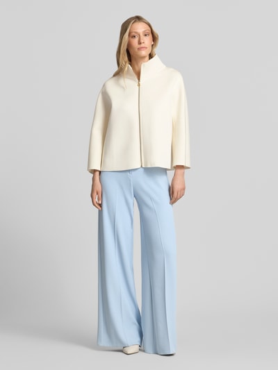 Frauenmodel trägt Blazer aus Viskose-Mix mit Stehkragen von Rinascimento in Creme, gerader Schnitt, Reißverschluss, Ganzkörperansicht von vorne.