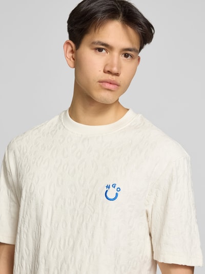 Männermodel trägt Regular Fit T-Shirt aus Frottee von Hugo Blue in Unifarbe Creme, kurzem Arm, Rundhals, Oberkörper Nahaufnahme.
