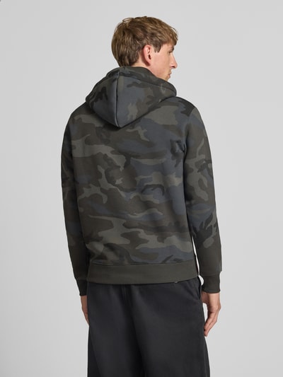 Männermodel trägt Regular Fit Hoodie aus Baumwoll-Mix mit Logo-Print von Alpha Industries in Grau Camouflage, Ganzkörperansicht Rückansicht.