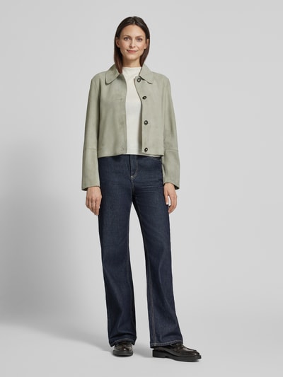 Vrouwenmodel draagt Regular Fit Lederjacke aus echtem Ziegenvelours van Marc O'Polo in effen kleuren, platte kraag, lange mouw, knoopsluiting, zij-steekzakken, velours, geitenleer, geheel vooraanzicht.