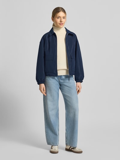 Frauenmodel trägt dunkelblaue Jacke mit Pattentaschen Modell 'CICAMI' von CINQUE, glatte Textur, Ganzkörperansicht von vorne. Regular Fit, Umlegekragen, Reißverschluss, Rückenlänge 58 cm, Schulterbreite 50 cm, Brustweite 56 cm, Ärmellänge 59 cm.