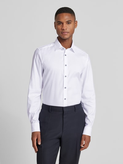 Männermodel trägt Slim Fit Businesshemd aus Baumwoll-Mix mit Kentkragen von OLYMP, weiß, lange Ärmel, elastisch, Ganzkörperansicht von vorne.