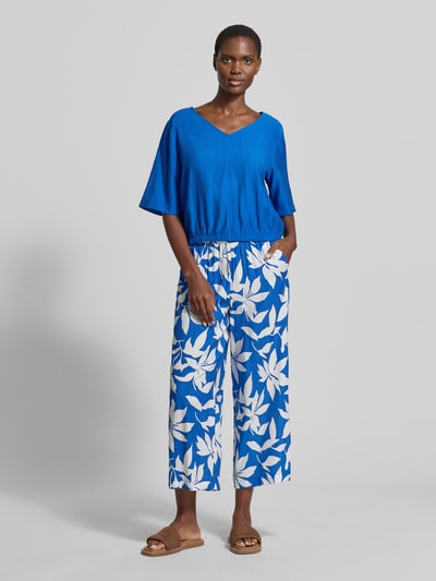 Frauenmodel trägt Relaxed Fit Blusentop aus Viskose-Mix von s.Oliver RED LABEL, leuchtend blau, Satin-Textur, kurzarm, Ganzkörperansicht von vorne.
