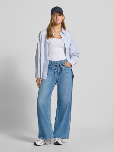 Frauenmodel trägt Oversized Weite Hose aus Baumwoll-Lyocell-Mix Modell '300®' von Levi's® 300, hellblaue Farbe, lockere Form, glatte Textur, Ganzkörperansicht von vorne.