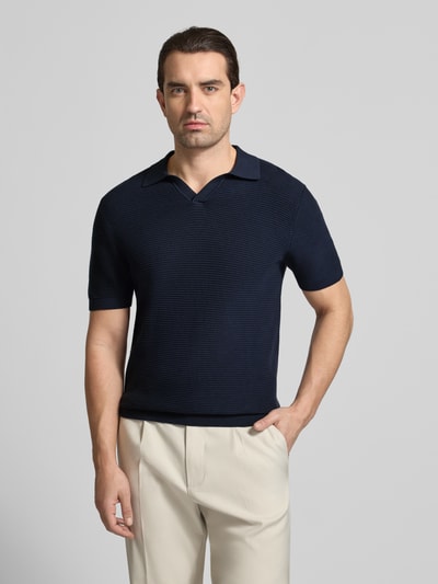 Męski model nosi Strickshirt mit Polokragen und V-Ausschnitt von Christian Berg Men, bawełna, krój regular fit, granatowy, długość tyłu 73 cm, rękaw 27 cm, całkowity widok z przodu.