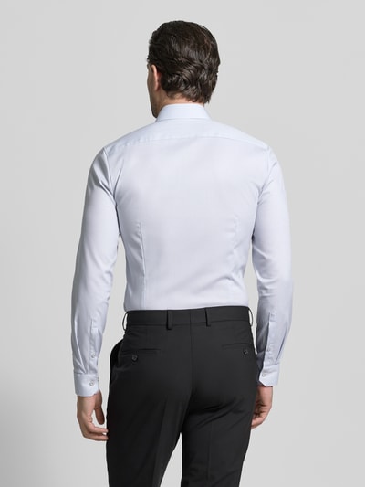 Męski model nosi Slim Fit Businesshemd mit Kentkragen od OLYMP No. Six, biały, bawełniany, krój slim fit, długie rękawy, widok całej sylwetki od tyłu.