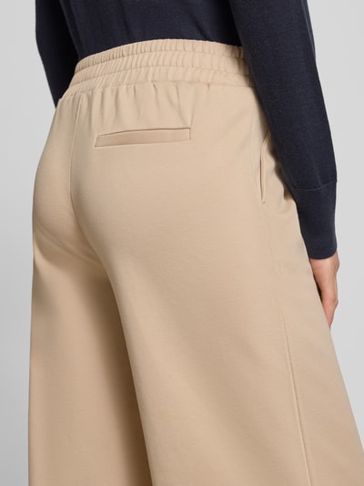 Frauenmodel trägt Hose mit weitem Bein Modell 'KATE' von ICHI in Beige, elastischer Bund, Gesäßtasche, Material-Mix, Nahaufnahme Rückansicht.