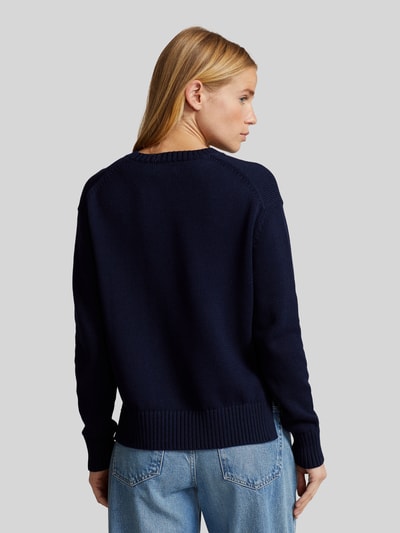 Frauenmodel trägt Regular Fit Strickpullover aus reiner Baumwolle von Polo Ralph Lauren in Dunkelblau, gerippte Abschlüsse, Rückansicht Ganzkörperansicht.