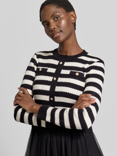 Kobieta modelka nosi 'Knielanges Kleid aus Viskose-Mix im 2-in-1-Look' od Apricot, mieszanka wiskozy, linia a, długość do kolan, efekt 2 w 1, okrągły dekolt, listwa guzikowa, długość tyłu w rozmiarze S: 107 cm, szerokość w rozmiarze S: 39 cm, długość rękawa w rozmiarze S: 58 cm, czarno-białe paski, dzianina o widocznej fakturze, z przodu, zbliżenie na górną część ciała.