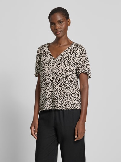 Frauenmodel trägt Bluse mit V-Ausschnitt Modell 'GRACE' von Vila mit Knopfleiste, beige-schwarz gemustert, Straight Fit, Nahaufnahme Oberkörper.